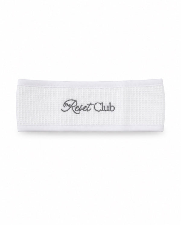The Reset Headband — white waffle-fabric headband embroidered with Reset Club